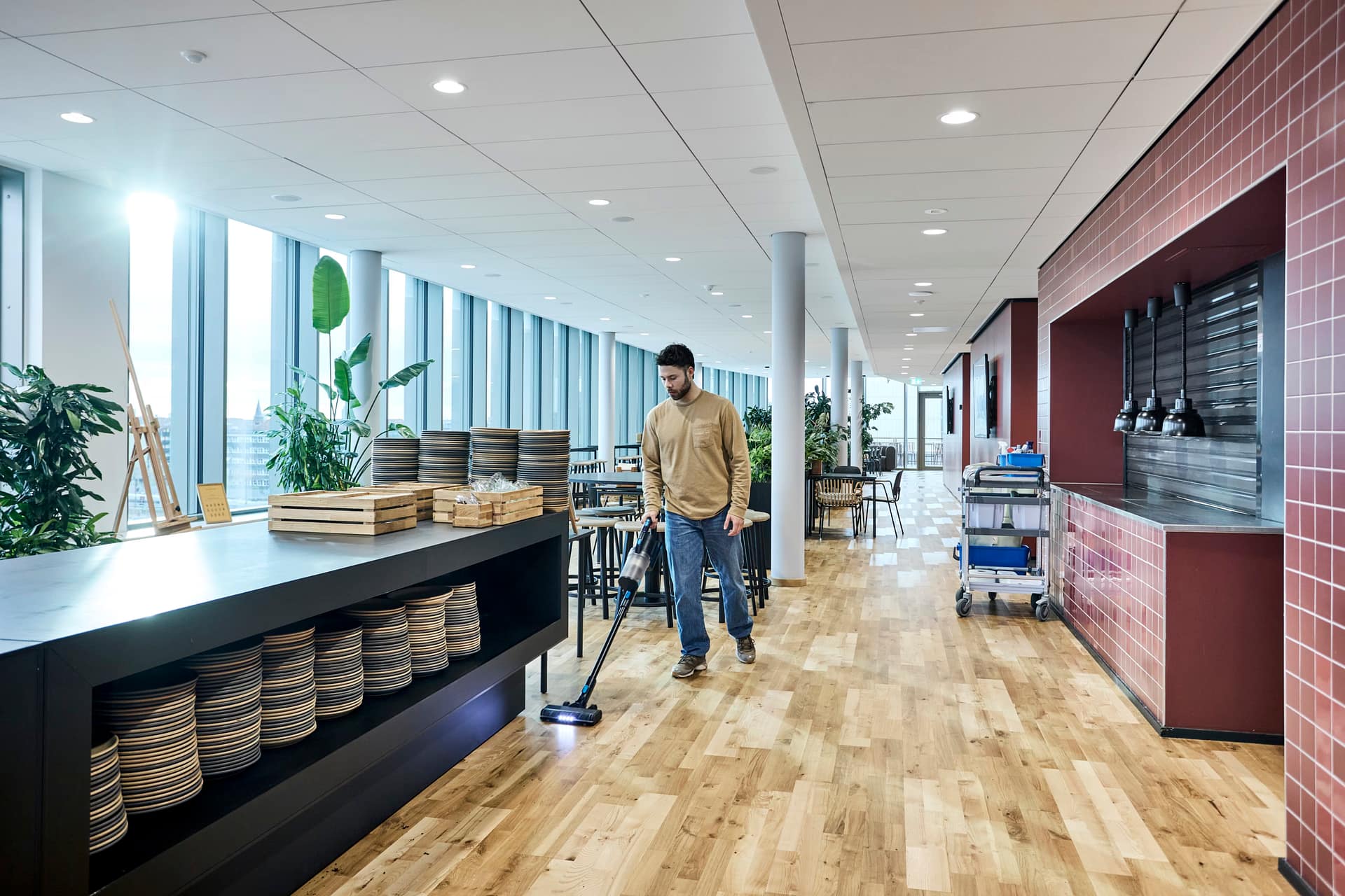 Nilfisk VU200 cordless vacuum cleaner being used in a canteen